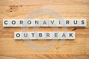 Word CORONAVIRUS OUTBREAK on wood background with copy space. Global novel coronavirus Covid-19 outbreak around the global world