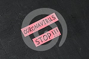 The word Coronavirus stop is written on a red piece of paper, on a black modern background. Epidemic, danger, recovery