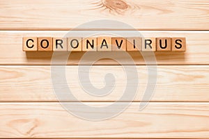 Word Coronavirus with wood blocks, cubes on wood background. COVID-19. Self-isolation concept. Coronavirus quarantine
