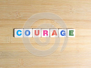 Word Courage on wood background