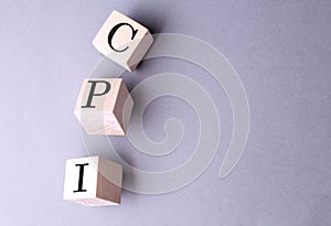 Word CPI on wooden block on the grey background