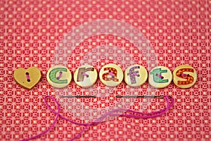 The word crafts spelled in hand painted letters on buttons