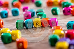 Word created with colored wooden cubes on desk.