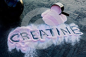 The word creatine written on spilled strawberry creatine on a black table