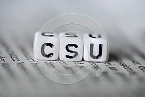 Word CSU formed by wood alphabet blocks on newspaper german party politics