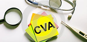The word CVA is written on a bright sticker on a light background near a stethoscope, magnifying glass and an electronic