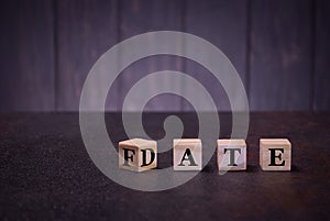 The word date fate on wooden cubes, on a dark background, light wooden cubes signs, symbols signs