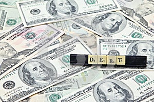 Word debt on pile of US dollar banknotes