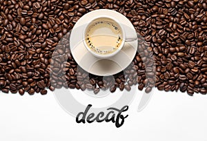 Word Decaf, cup of coffee and beans on white background, flat lay