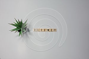 The word Decency written in wooden letter tiles on a white background