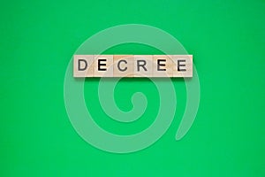 Word decree. Top view of wooden blocks with letters on green surface