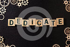 Word Dedicate on a row of wooden blocks. Devotion dedication love concept. photo