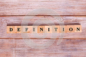 Word definition written on wood block on wooden background. Business concept