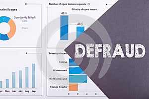 The word DEFRAUD is written on a gray background with diagrams and graphs photo