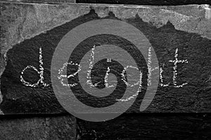 The word DELIGHT written with chalk on black stone.