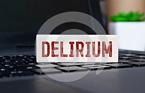word delirium made of wooden letters on a gray table on a green background