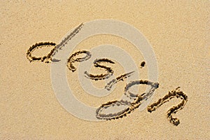 The word design handwritten in sand on a beach