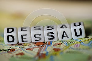 Word DESSAU formed by alphabet blocks on atlas map