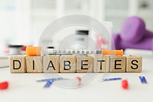 Word Diabetes made with wooden cubes and syringe on table