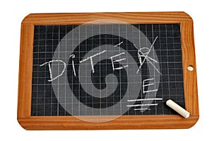 The word dictation written in french and corrected on a school slate with chalk close-up on a white background