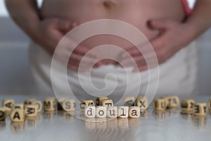 Word DOULA composed of wooden letters