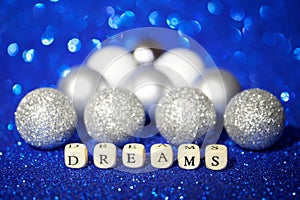 The word dream is laid out in cubes on a shiny blue background. Fantasy and fairy tales. Bokeh
