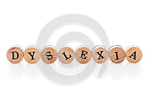 Word Dyslexia from circular wooden tiles with letters children toy.