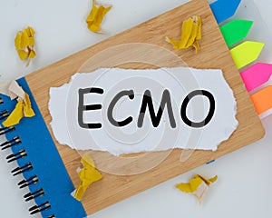 The word ecmo is written on a torn piece of paper on a notepad. the concept of business, marketing