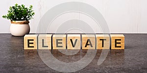 word elevate made with wood building blocks