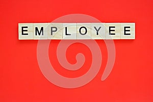 Word employee. Top view of wooden blocks with letters on red surface