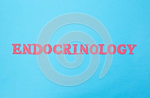 The word endocrinology on a blue background. The concept of the section of medicine dealing with the treatment of diseases of the