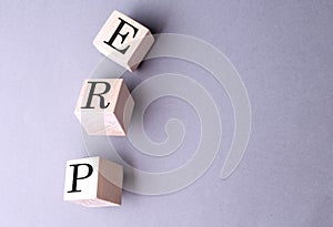 Word ERP - Enterprise Resource Planning on wooden block on the grey background