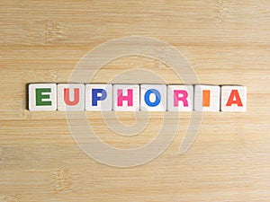 Word Euphoria on wood background