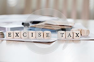 Word EXCISE TAX is composed of wooden letters.