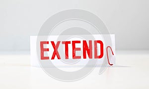 The word EXTENDE is written in the notebook with office tools