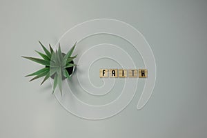 The word Faith written in wooden letter tiles on a white background