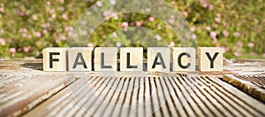 The word fallacy written on the cubes in black letters