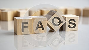 word Faqs on wooden cubes, gray background