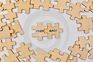 Word FEEDBACK made of wooden puzzle pieces on white background