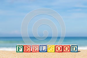 Word FEELGOOD in colorful alphabet blocks on tropical beach