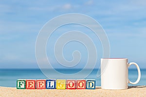 Word FEELGOOD in colorful alphabet blocks on tropical beach