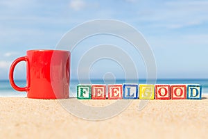 Word FEELGOOD in colorful alphabet blocks on tropical beach
