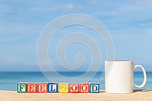 Word FEELGOOD in colorful alphabet blocks on tropical beach photo