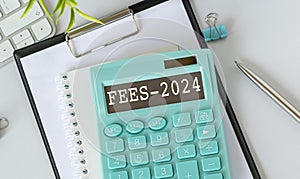 Calculator, currency, book, tax form, and pen on white desk table.