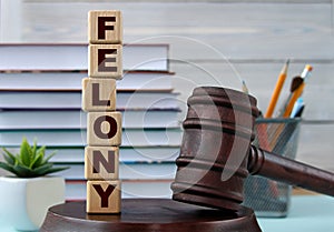 The word FELONY on wooden cubes against the background of the judge's gavel and stand