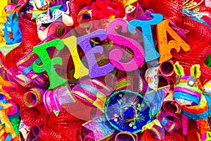 The word `fiesta` written in colorful foam letters on multicolored mash decorated with glitter and small sombrero