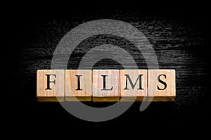 Word FILMS isolated on black background with copy space