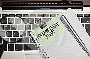 The word Follow these steps on torn paper on red notepad
