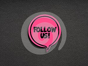 The word follow us on pink speech bubble on black background. Follow us business technology social media concept