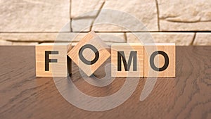 word FOMO block wood on wooden table background